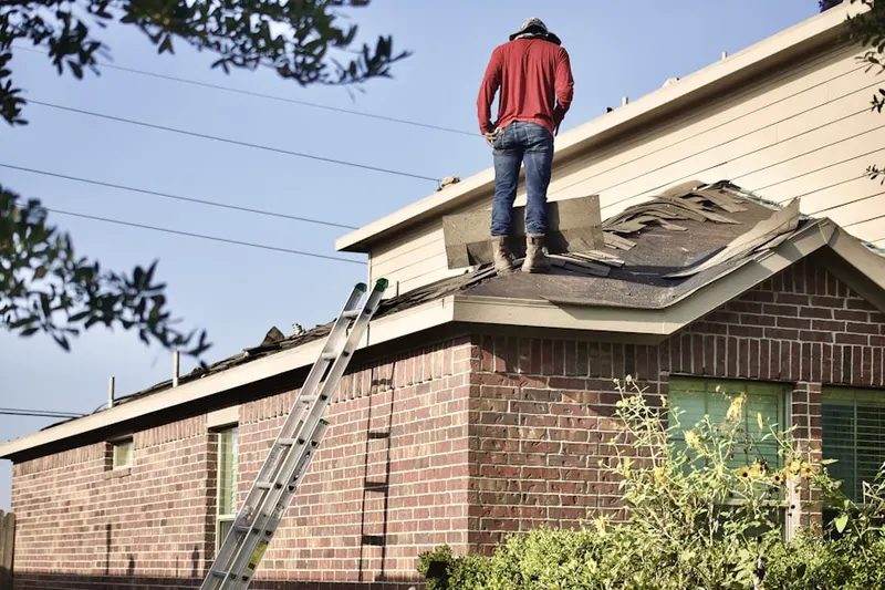 Professional roofer working on a residential roof in Athenia
